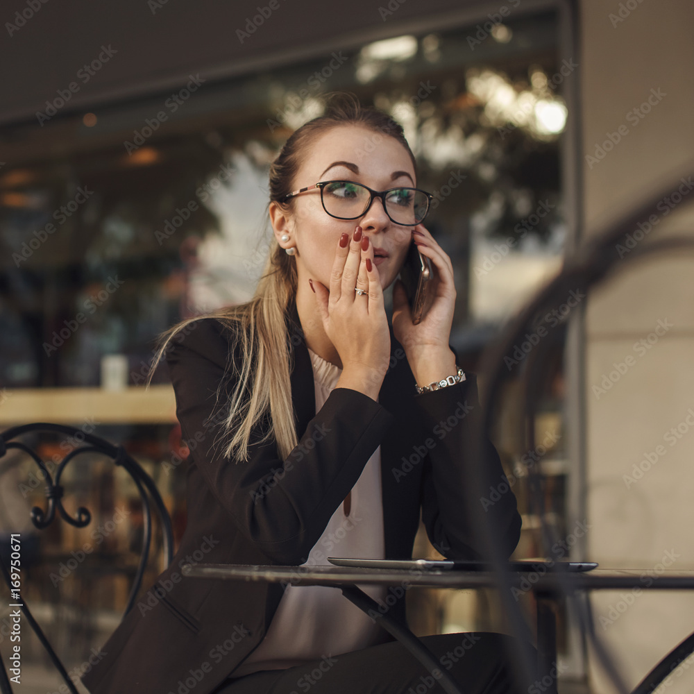 Fototapeta premium Business woman telling a secret by the phone