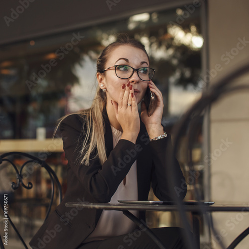 Business woman telling a secret by the phone