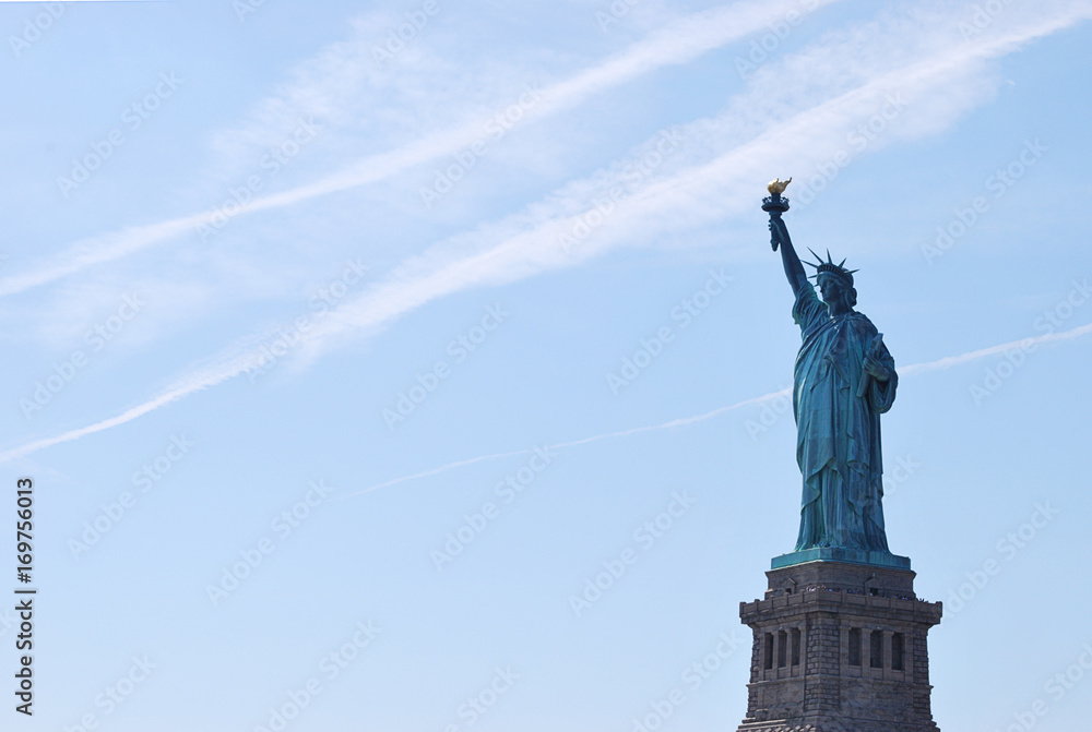 Fototapeta premium Freiheitsstatue vor blauem bewölkten Himmel