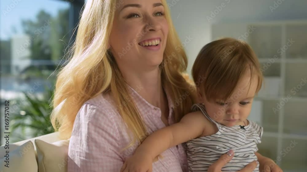 Positive woman keeping the child in arms Positive woman keeping the child in arms
