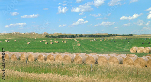 Hay bales and prairie in southern South Dakota with ideal blue sky and white puffy clouds photo