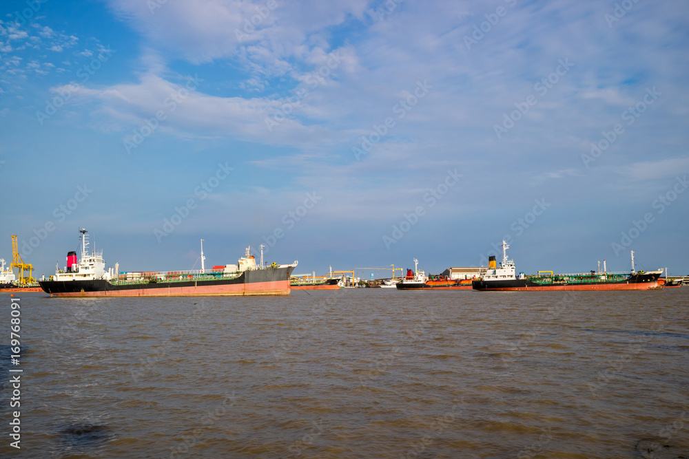 Oil gas tanker ship, container cargo ship at river port. Logistics industrial and transportation business concept