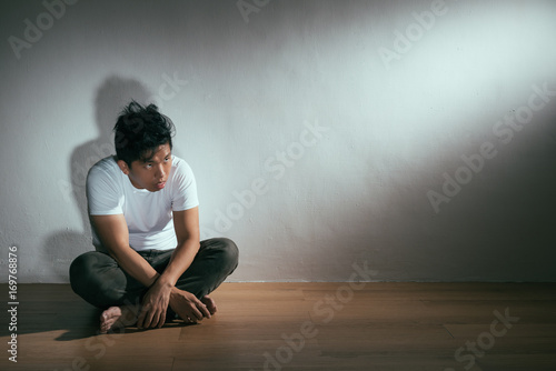 young autism patient man sitting on wooden floor