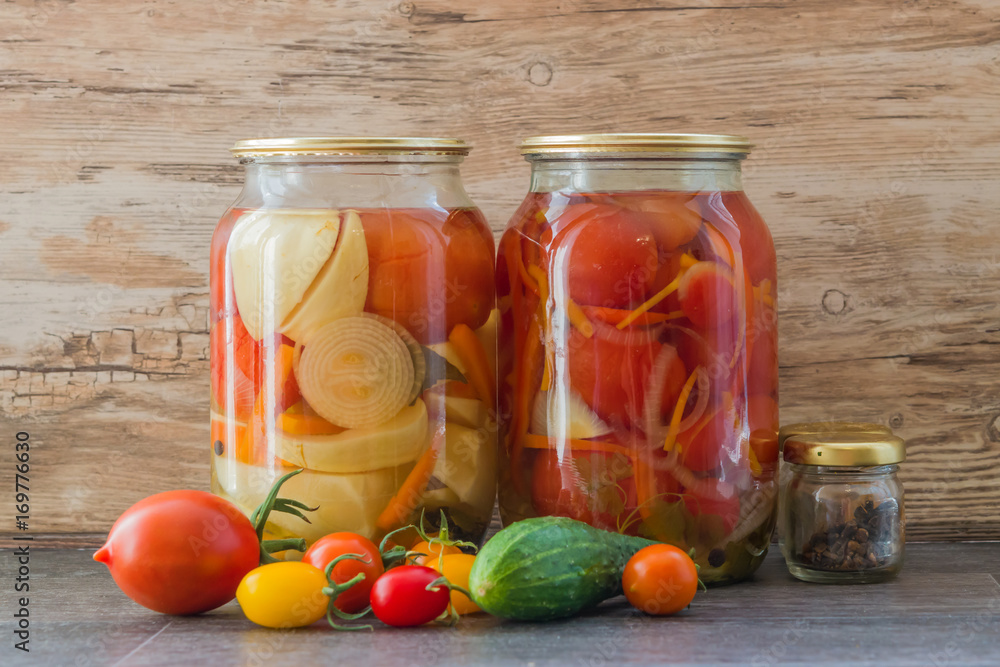 Preserving fresh vegetables red tomatoes in two glass jars on wooden background surface Preserving fresh vegetables red tomatoes in two glass jars on wooden background surface