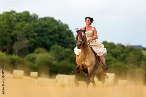 mature woman riding an Andalusian horse © Christian Müller