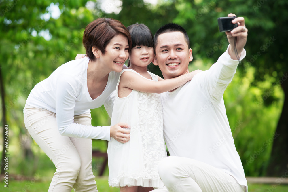 Young happy Asian family spending time together at the park. Young happy Asian family spending time together at the park.