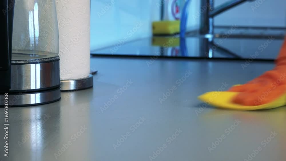 A man with rubber gloves cleans a kitchen counter with a cloth - closeup A man with rubber gloves cleans a kitchen counter with a cloth - closeup