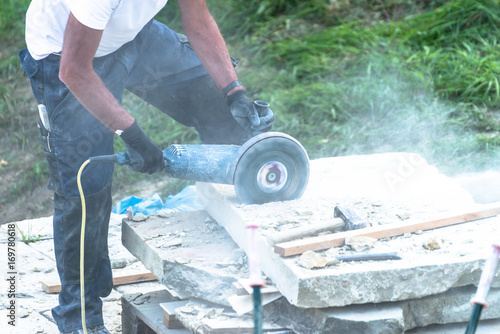 Bauarbeiter schneidet einen Steinblock mit einem Trennschleifer 