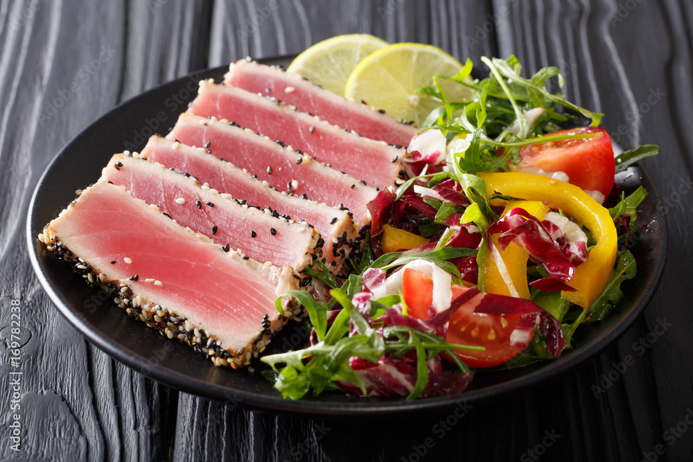 beautiful food: steak tuna in sesame, lime and fresh salad close-up on a plate on the table. horizontal
