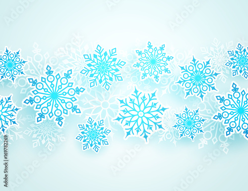 Winter vector background with falling snowflakes of different shapes in white background with empty space for text. Vector illustration.
