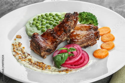 Plate with delicious ribs, vegetables and mushy peas, closeup