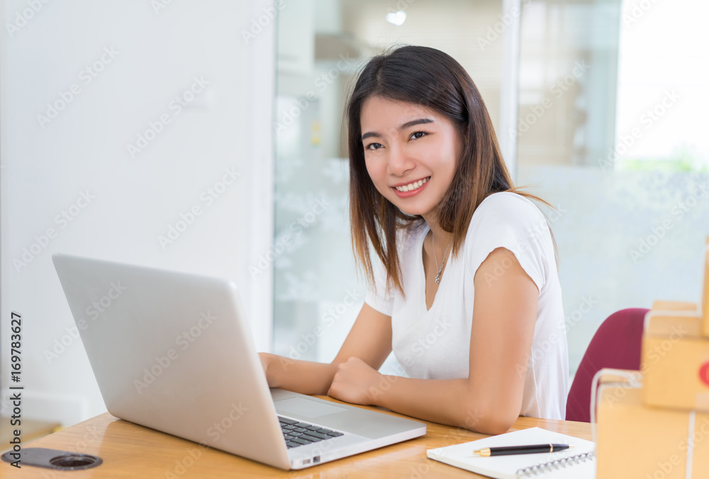 Young asian girl freelancer business private working at home office with laptop, note, coffee, packaging delivery online market on purchase orders to customer. Young asian girl freelancer business private working at home office with laptop, note, coffee, packaging delivery online market on purchase orders to customer.