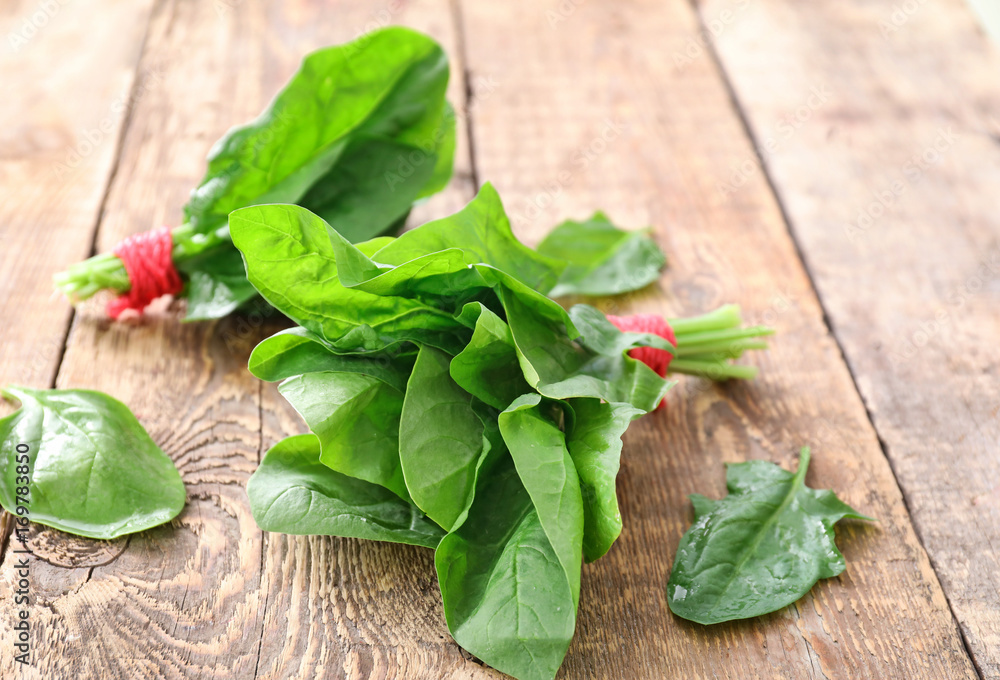 Fresh spinach bunches on wooden background Fresh spinach bunches on wooden background