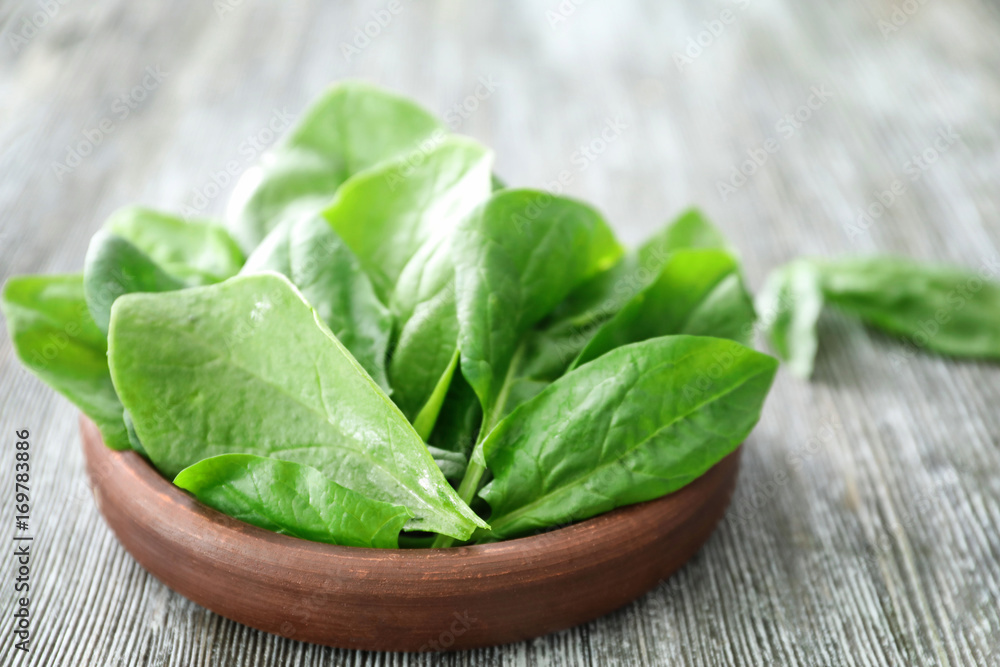 Bowl with fresh spinach leaves on table Bowl with fresh spinach leaves on table
