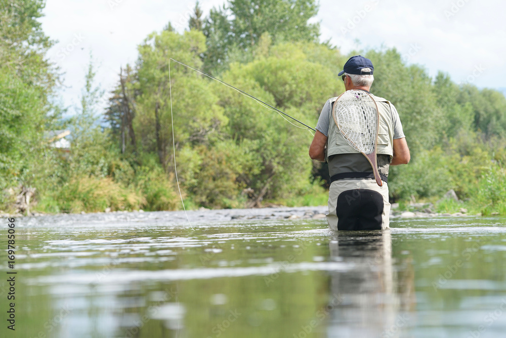 Fly-fisherman fishing in the Gallatin River, Montana Fly-fisherman fishing in the Gallatin River, Montana