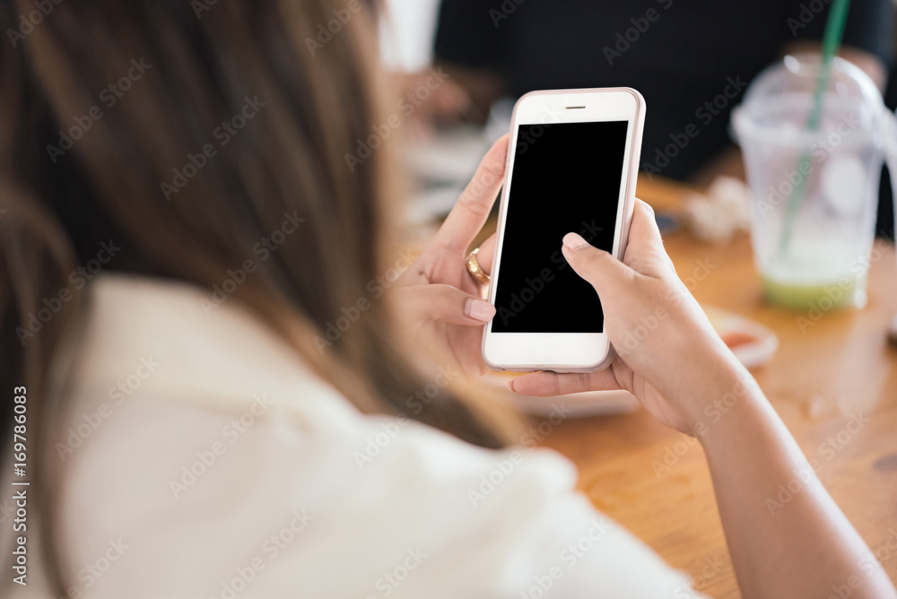 Close up of Asian women's hands holding cell telephone with blank copy space scree for your advertising text message or promotional content, Concept : working, meeting, study, education in coffee shop