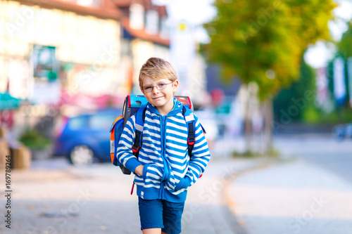 little kid boy with school satchel on first day to school