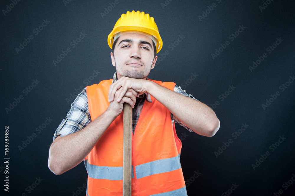 Constructor wearing equipment resting on hoe tool Constructor wearing equipment resting on hoe tool