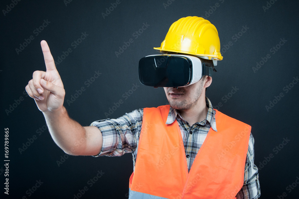 Constructor wearing vr goggles gesturing with index finger Constructor wearing vr goggles gesturing with index finger