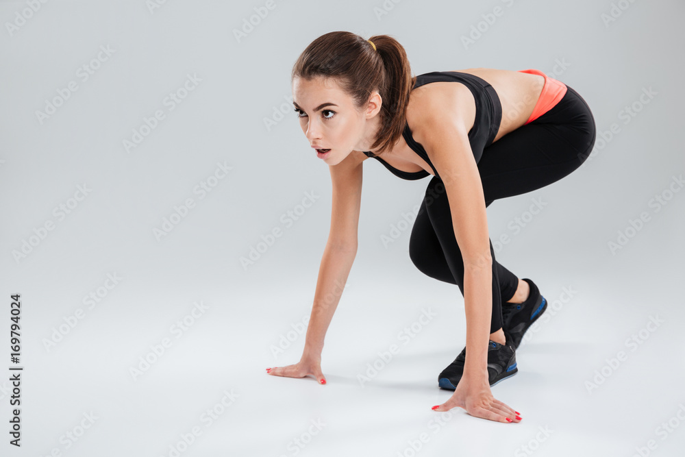 Concentrated fitness woman preparing to run in studio Concentrated fitness woman preparing to run in studio