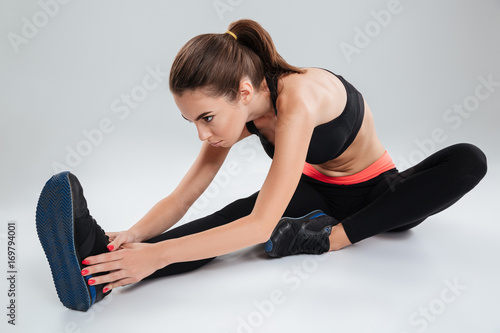 Concentrated fitness woman sitting on the floor