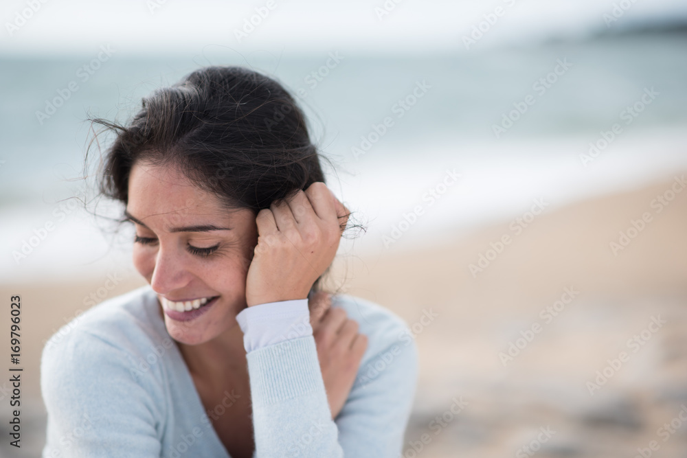 Fototapeta premium Portrait of a beautiful young brunette woman on the beach