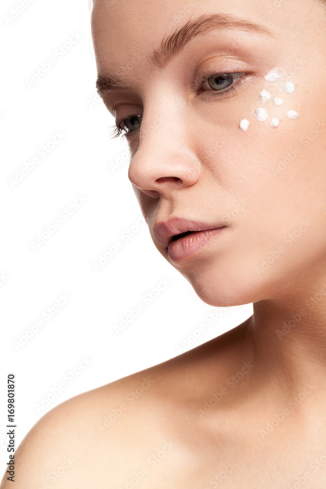 Portrait of Gorgeous beautiful woman with cream face drops on her face. Studio photo. Beauty and skin care Portrait of Gorgeous beautiful woman with cream face drops on her face. Studio photo. Beauty and skin care