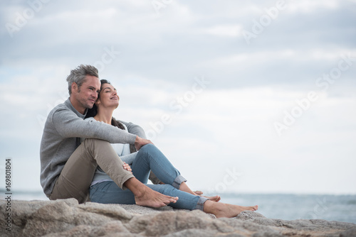 Portrait of a middle-aged couple sitting on the beach photo