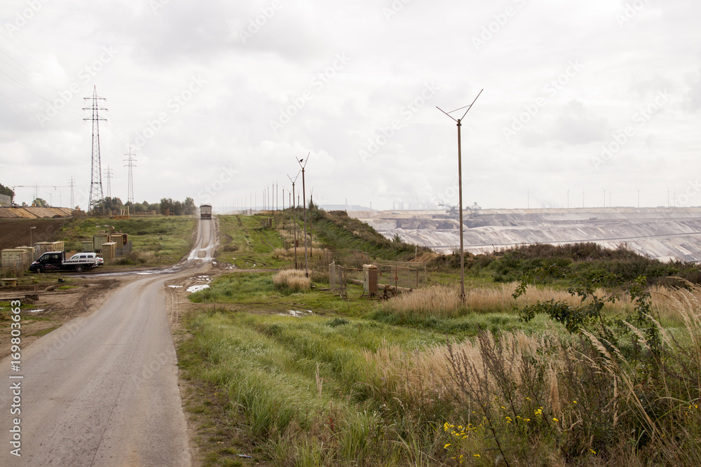Germany, North Rhine Westphalia, -june 2017: ground excavator in action moving mullock and soil at open pit coal mine; Germany,for winning brown coal Germany, North Rhine Westphalia, -june 2017: ground excavator in action moving mullock and soil at open pit coal mine; Germany,for winning brown coal