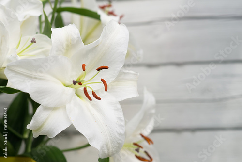 Fototapeta Naklejka Na Ścianę i Meble -  White lilies on light wooden background