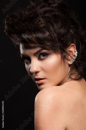 Gorgeous brunette model in studio photo on black background. Perfect make up and hairstyle