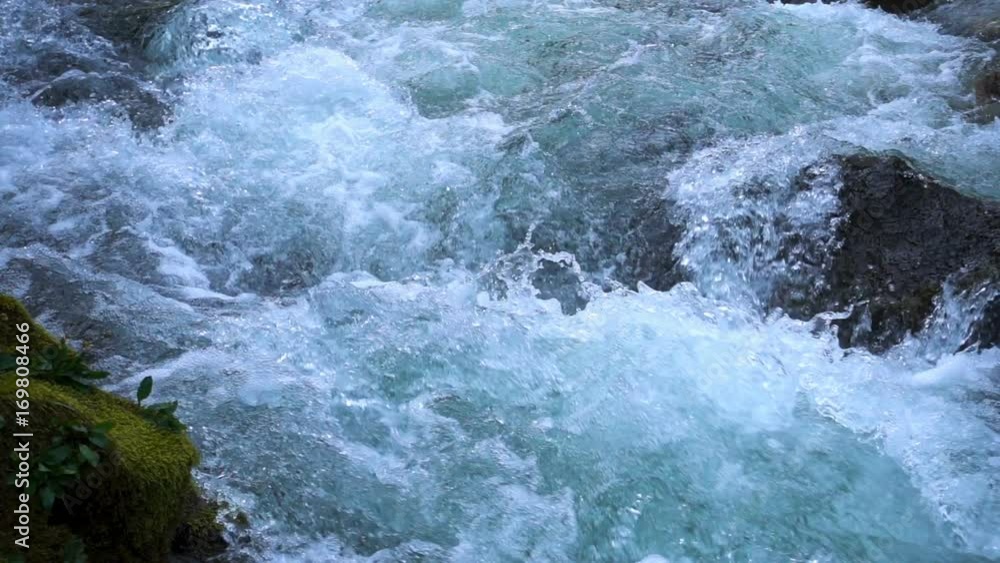 SLOW MOTION: flowing water over stones in mountines river SLOW MOTION: flowing water over stones in mountines river