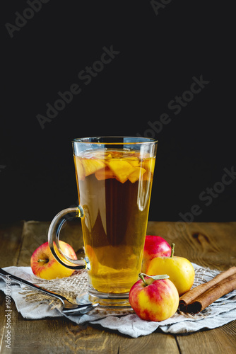 Cup of tea with apple and spices on wooden background Vertical Toned