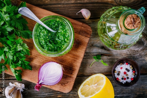 Ingredients for chimichurri sauce: fresh parsley, red onion, garlic, olive oil, lemon photo
