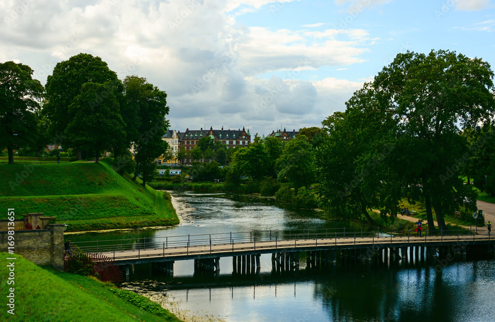 Copenhagen cityscape, Denmark. Old architecture and green park on a canal bank, panoramic view of European city Copenhagen cityscape, Denmark. Old architecture and green park on a canal bank, panoramic view of European city