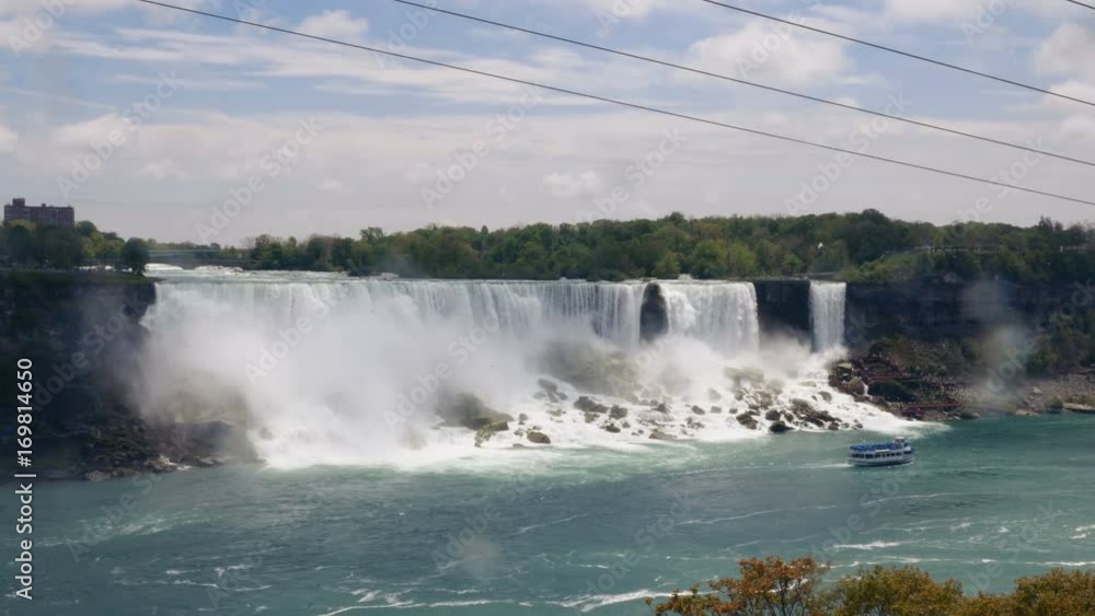 American Falls filmed from the Canadian side of the Niagara River. A boat sails underneath. Long shot. American Falls filmed from the Canadian side of the Niagara River. A boat sails underneath. Long shot.