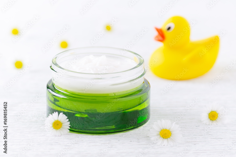 natural baby cosmetic, cream and chamomile flowers, a duck, selective focus natural baby cosmetic, cream and chamomile flowers, a duck, selective focus