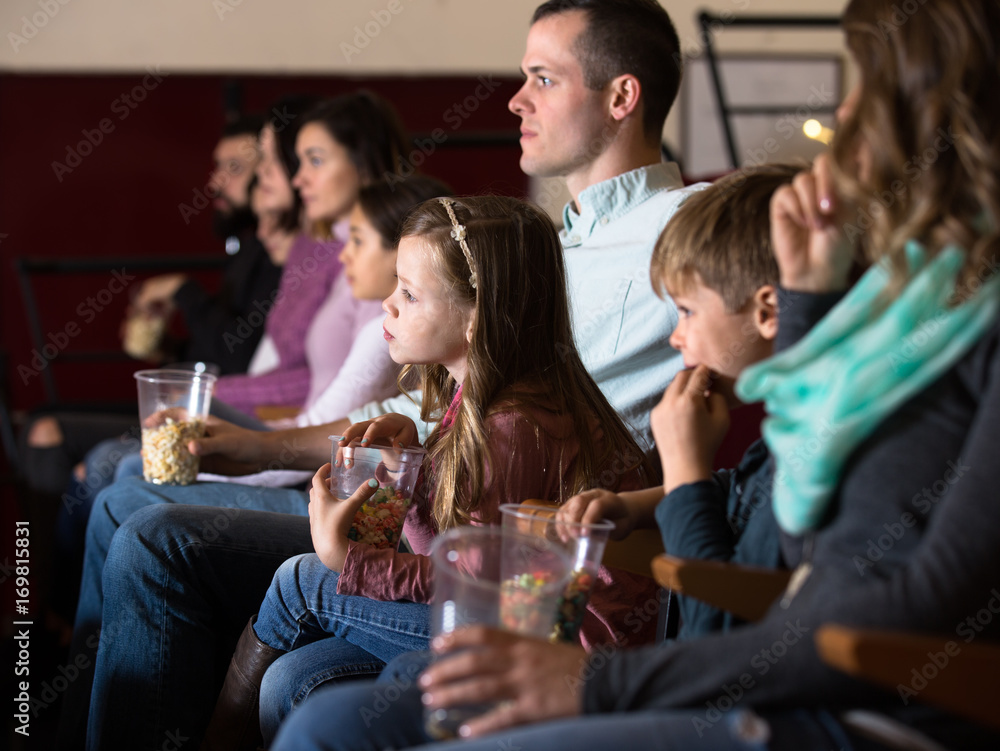 Spectators eating popcorn and enjoy watching movie