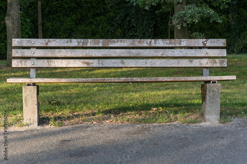 A single wooden park bench in the park