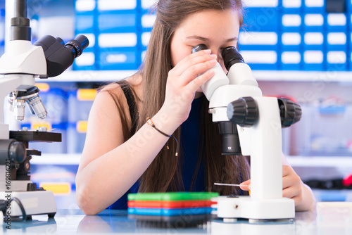 A teenage girl in a school laboratory in chemistry and biology classes