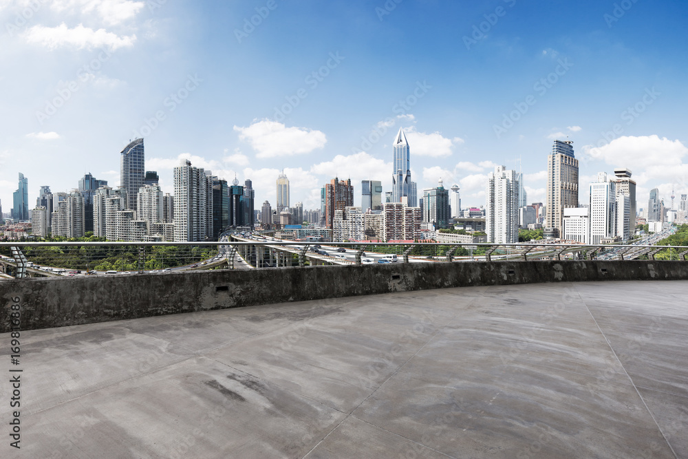 empty concrete road with cityscape of modern city in blue sky