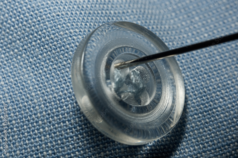 Sewing a button to a cotton cloth macro Sewing a button to a cotton cloth macro