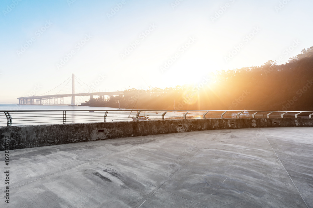 Fototapeta premium empty concrete road with suspension bridge in blue sky