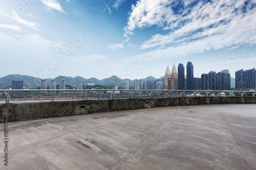 empty concrete road with cityscape of modern city in blue sky