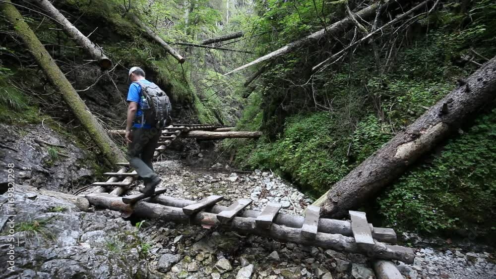 Backpacking hiker man going through rocky canyon Backpacking hiker man going through rocky canyon