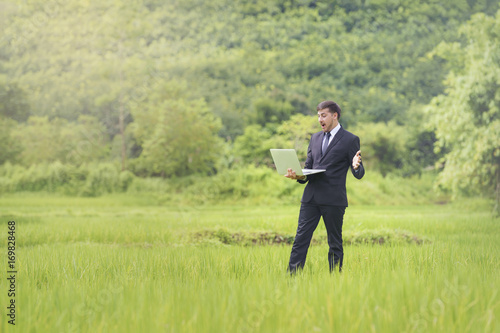 Young researchers - marketers study rice varieties with notebooks. Green meadow