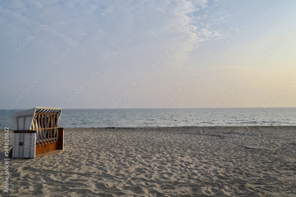 Einzelner Strandkorb am Meeresstrad in der Abendsonne mit viel Freiraum