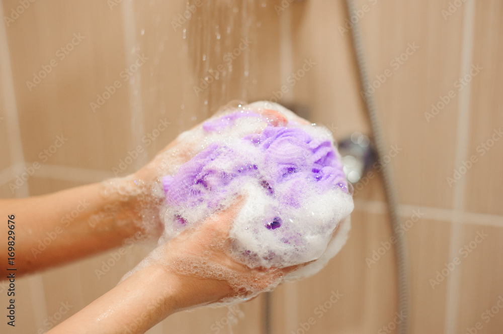 Fototapeta premium woman using a soap while taking shower in bathroom
