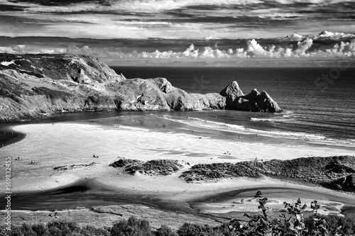 Black and white monochrome image of Three Cliffs Bay on the Gower Peninsular, West Glamorgan, Wales, UK, which is a popular Welsh coastline attraction of outstanding beauty photo