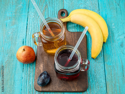 Glasses of juise with fruits on table photo